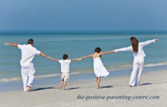 the positive parenting centres Happy family walking on beach the positive parenting centres Happy family walking on beach